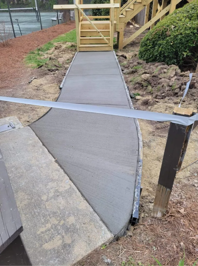 New smooth concrete walkway poured beside outdoor stairs