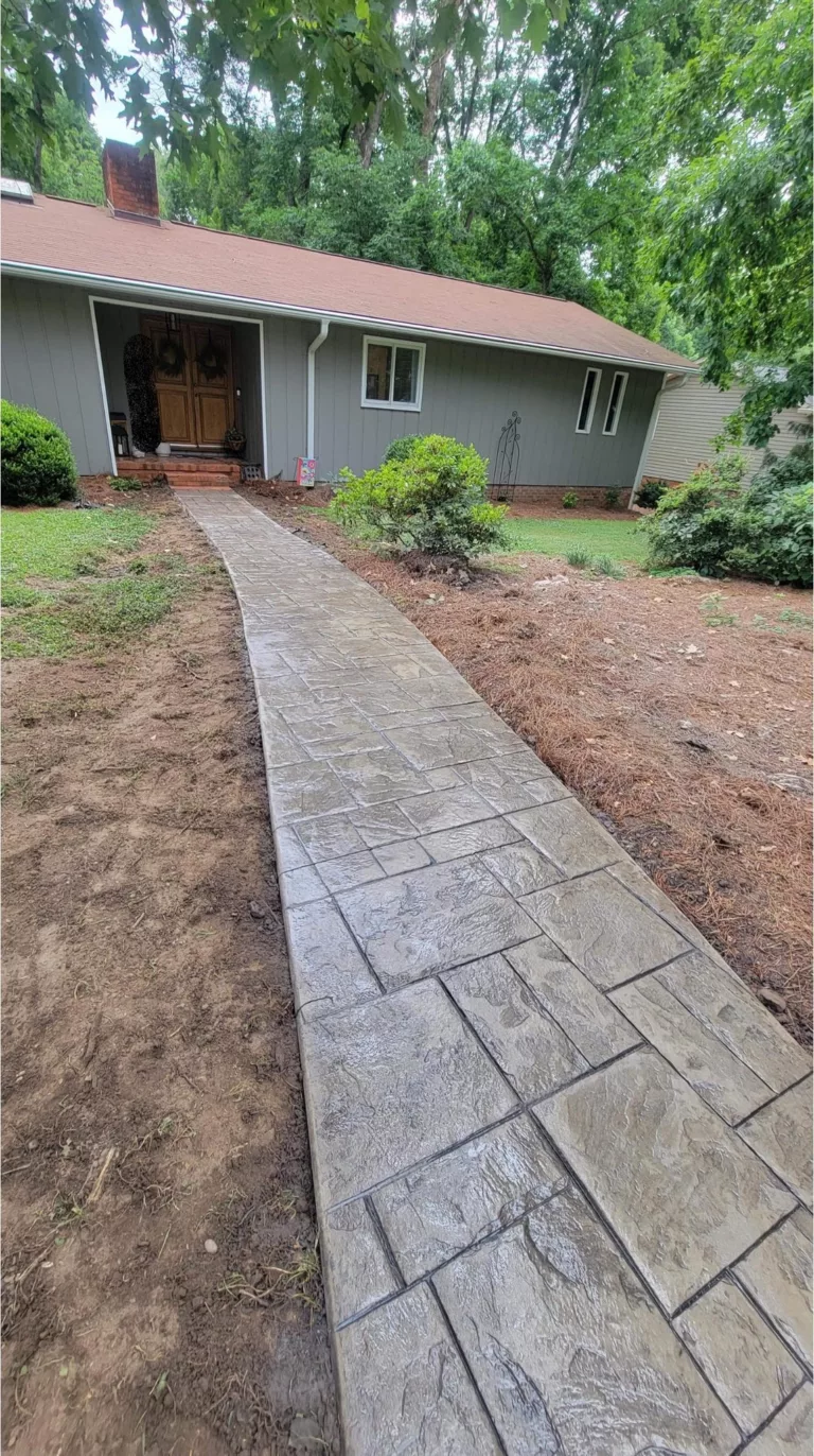 Long stamped concrete walkway leading to a home entrance