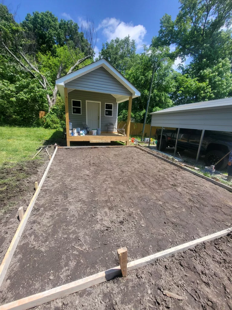 Small house with freshly prepared garden bed.