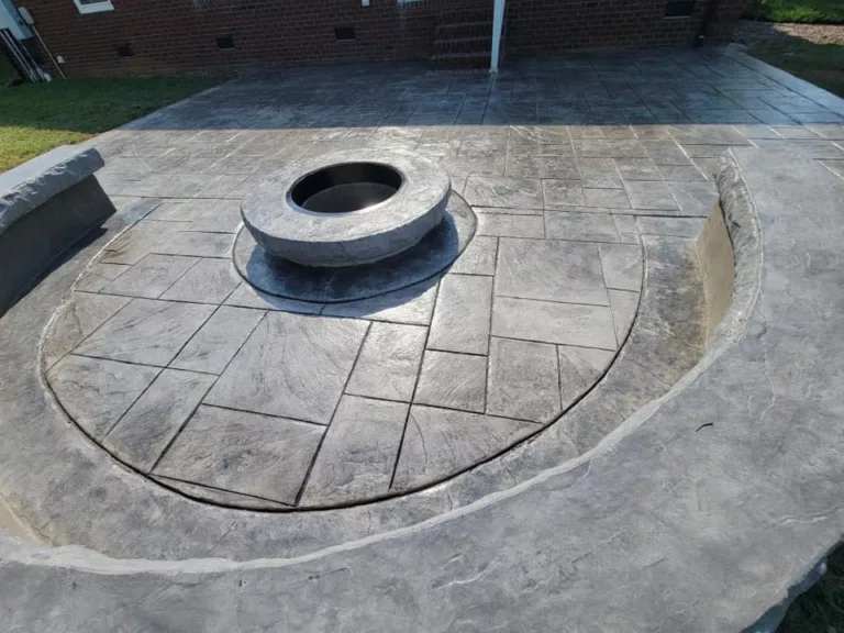 Circular stamped concrete patio surrounding a stone fire pit