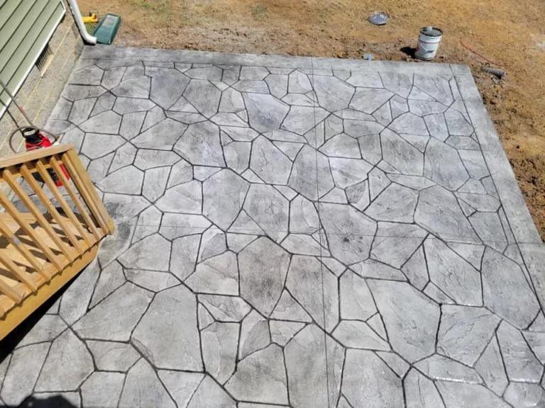 Overhead view of a gray stamped concrete patio beside a deck