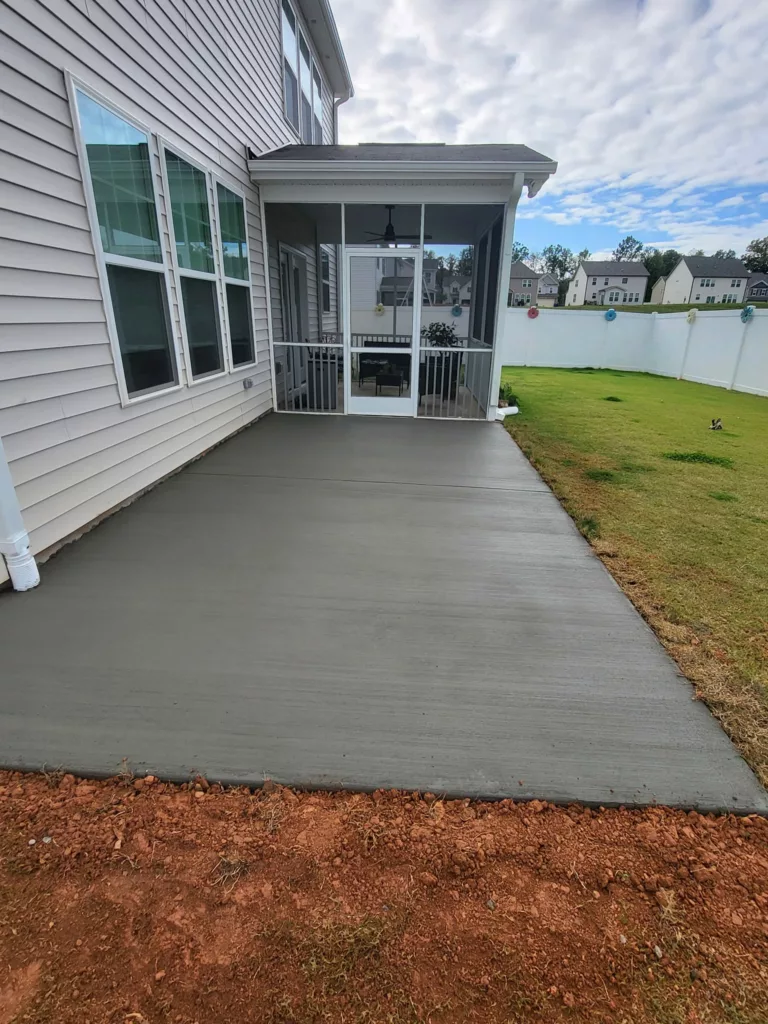 New smooth concrete patio outside a screened porch