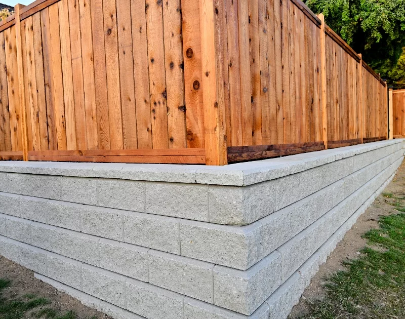 Wooden fence on sturdy stone retaining wall