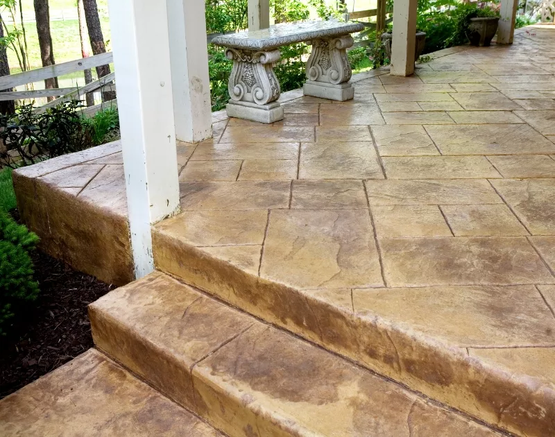 Stamped concrete porch with decorative stone bench.